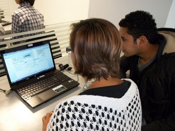 Mujer y hombre mirando un computador 