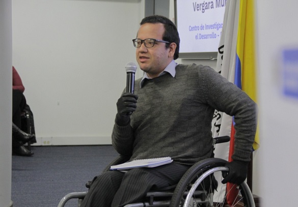 Hombre en silla de ruedas con un micrófono en la mano
